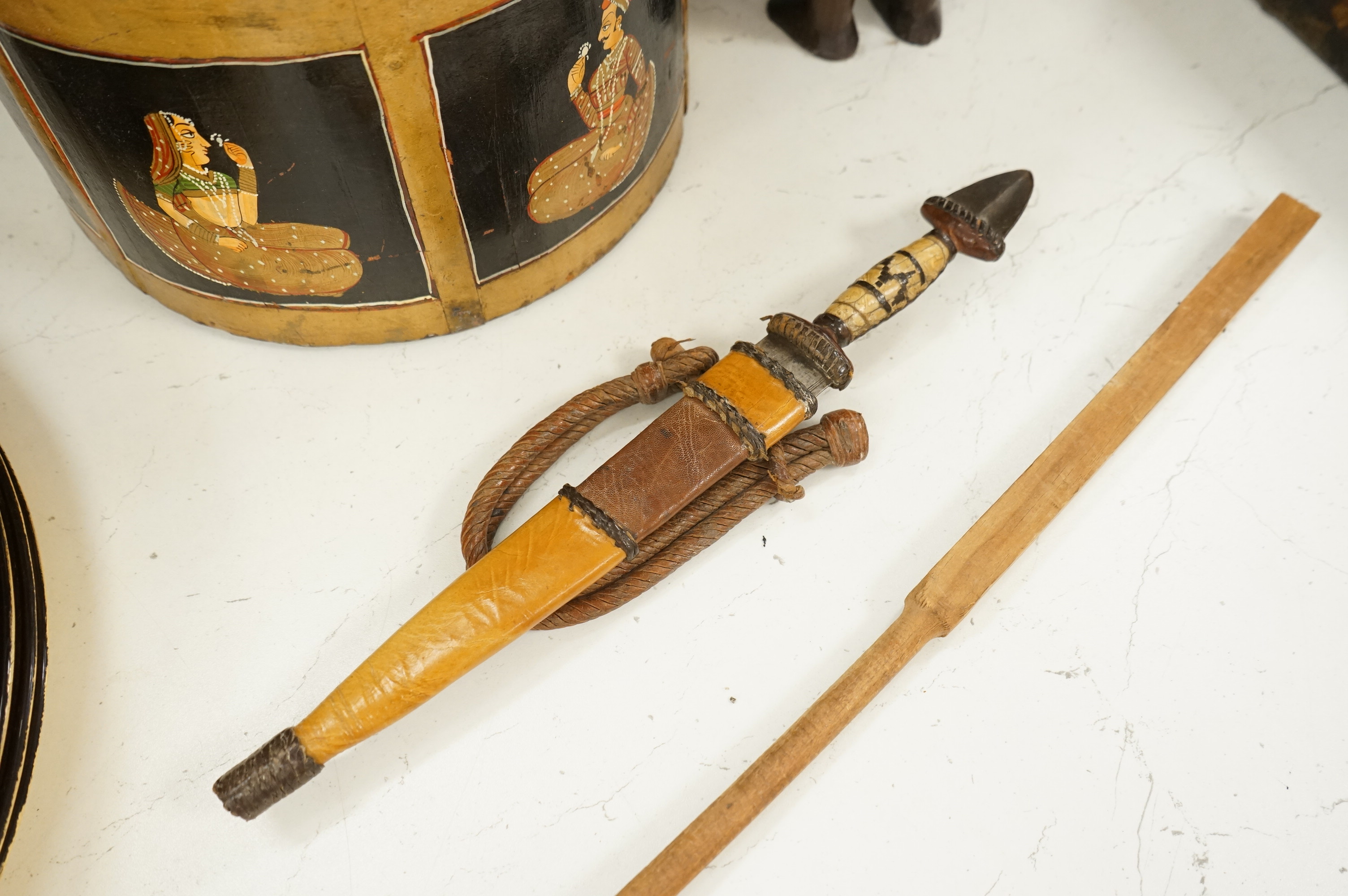 A collection of tribal and Asian collectables including a Tibetan prayer wheel, carvings, etc.